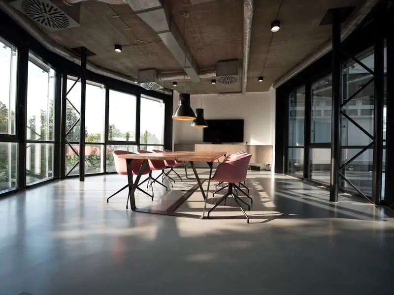Sala de reuniones con mesa de madera y pantalla